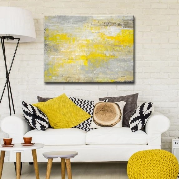 طراحی داخلی اتاق نشیمن با دیوار آجری سفید که از وسایل و دکوریجات با رنگ گرم زرد در آن استفاده شده است